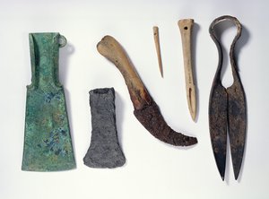 Utvalg av verktøy: L-R: bronseøks fra tidlig jernalder med bøyde vinger; senere jernøks; kniv med beinhåndtak; bein nål; bein syl; jernskjær